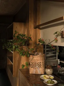 A decorative bamboo planter with green leaves and red berries sits on a wooden counter, enhancing the interior design.