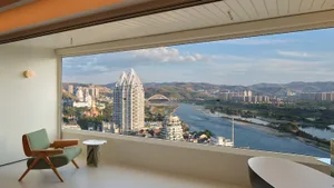 從窗戶眺望現代飯店建築群，背景有河流與城市景觀。