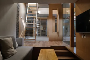 A minimalist living space featuring wooden elements and stairs.