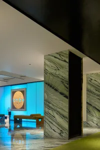 Modern hotel lobby featuring marble walls and glass elements.