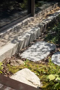 Lush green Japanese garden with a stone path and gravel landscaping.