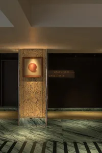 A modern lobby with wooden panels and marble accents.