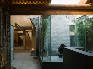 A modern minimalist lobby with transparent glass walls and minimalist design elements.