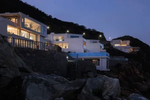 A modern residential building with concrete and glass exteriors.
