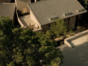A modern residential exterior featuring concrete walls and a roof with a mix of concrete and wooden materials.
