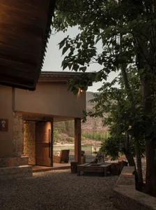 A modern residential exterior featuring wood and stone materials.