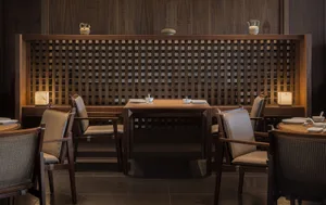 Modern restaurant interior with wooden furniture and lattice partitioning.