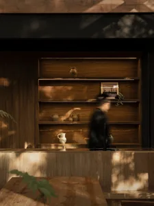 A modern kitchen with wooden shelves displaying various ceramic vessels.