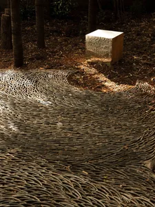 An abstract wooden sculpture with a modern design featuring an intricate wave-like pattern.