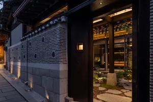 Stone storefront of a retail establishment with wooden accents at dusk.
