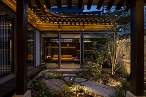 A traditional-style interior living space featuring a rock garden and wooden beams.