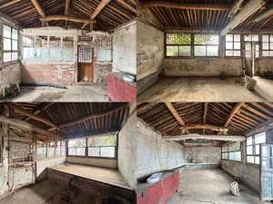 An old abandoned building's interior with concrete floors and brick walls.