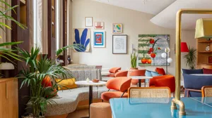 A colorful cafe space featuring modern furniture and vibrant plants.