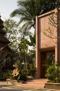 A concrete entrance with steps, a door, and surrounding greenery.
