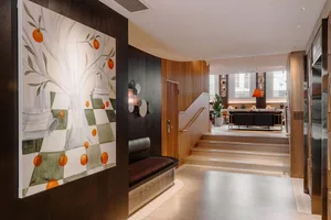 A hotel lobby with wooden benches, tiled floors, and modern furniture.