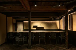 An industrial-style restaurant bar featuring wooden elements and a minimalist design.