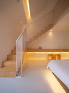 Modern residential bedroom featuring minimalist design with wooden flooring and glass windows.