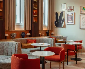 A modern cafe interior designed with fabric seating and marble tables.