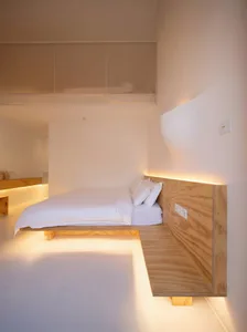 A modern minimalist bathroom with a white color scheme and wooden finishes.