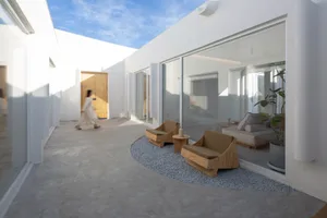Modern residential patio with concrete flooring and minimalist furniture.