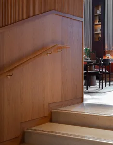 Staircase with wood railings and textured wall