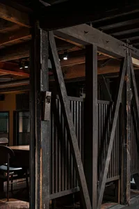 An interior space featuring industrial design elements with prominent wood beams.