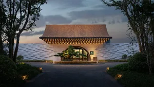 A modern entrance gate with a stone archway and a desert path.