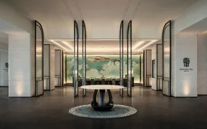 A modern hotel lobby featuring marble, glass, and metal materials