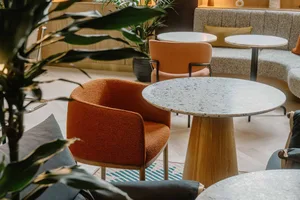 An image showcasing a modern interior with a combination of concrete and terrazzo materials, featuring comfortable seating op