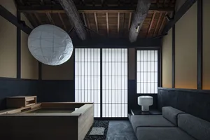 A modern living room with a minimalist and wabi-sabi aesthetic, featuring wood and concrete materials and a large lantern pen