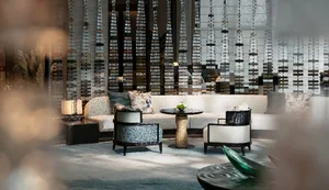 Modern lounge area with textured fabric seating, round tables, and decorative elements.