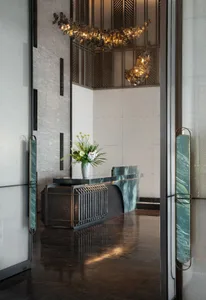 Modern lobby reception with marble counter, concrete texture, brass accents, and floral arrangement.
