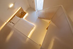 A modern minimalist bedroom with white wooden furniture and a minimalist design aesthetic.