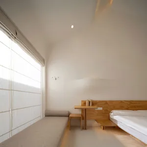 A minimalist bedroom featuring modern design elements and wooden furniture.