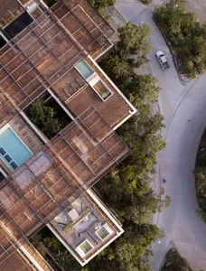 Aerial view of a modern residential building with a wooden roof and rooftop terrace.