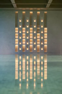 A modern swimming pool decorated with reflective glass panels, creating a serene and luxurious atmosphere.
