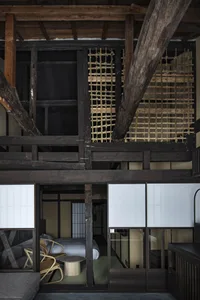 A traditional Japanese bedroom featuring wooden structures and a tatami mat floor.