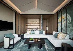 Modern living room featuring white leather sofa, black coffee table, concrete floor, and glass windows.