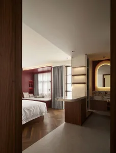 A modern bedroom with wood flooring, a marble counter, and a combination of wooden and marbled elements.