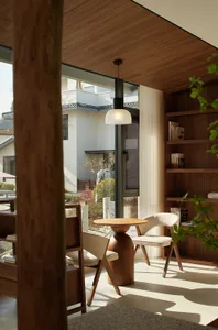 A minimalist interior with wooden furniture and a circular wooden table.