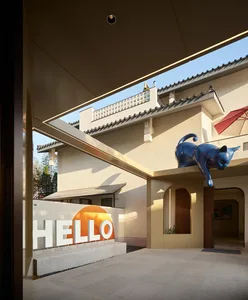 Modern building exterior made of concrete with a large, bold sign reading 'HELLO'.