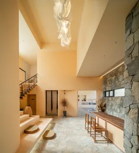 A modern hotel lobby with a neutral color scheme featuring a stone fireplace and wooden furniture.