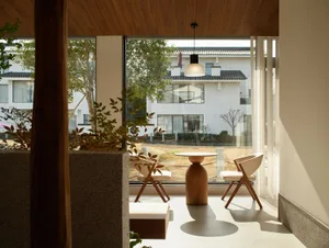 Modern living room with corner seating, minimalist design, and natural light.