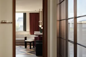 A modern residential room with wooden furniture, ceramic floor tiles, and minimalist decor.