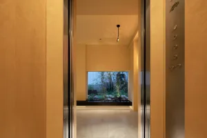 An open-plan industrial-style lobby with concrete walls and floor, featuring a minimalist design.