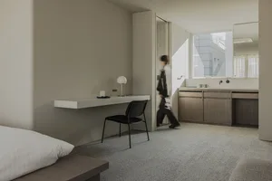 A modern hotel room with a concrete floor and minimalist design.