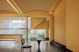 A modern lobby with glass walls and a table.