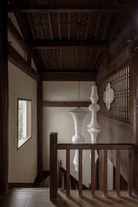 Modern staircase with white pendant lights and wooden railings in an interior setting.