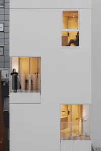 A rendering of a modern apartment building with white exterior walls.
