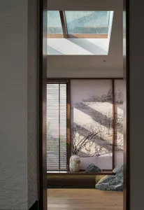 A minimalist living room with a paper wall depicting a winter landscape.